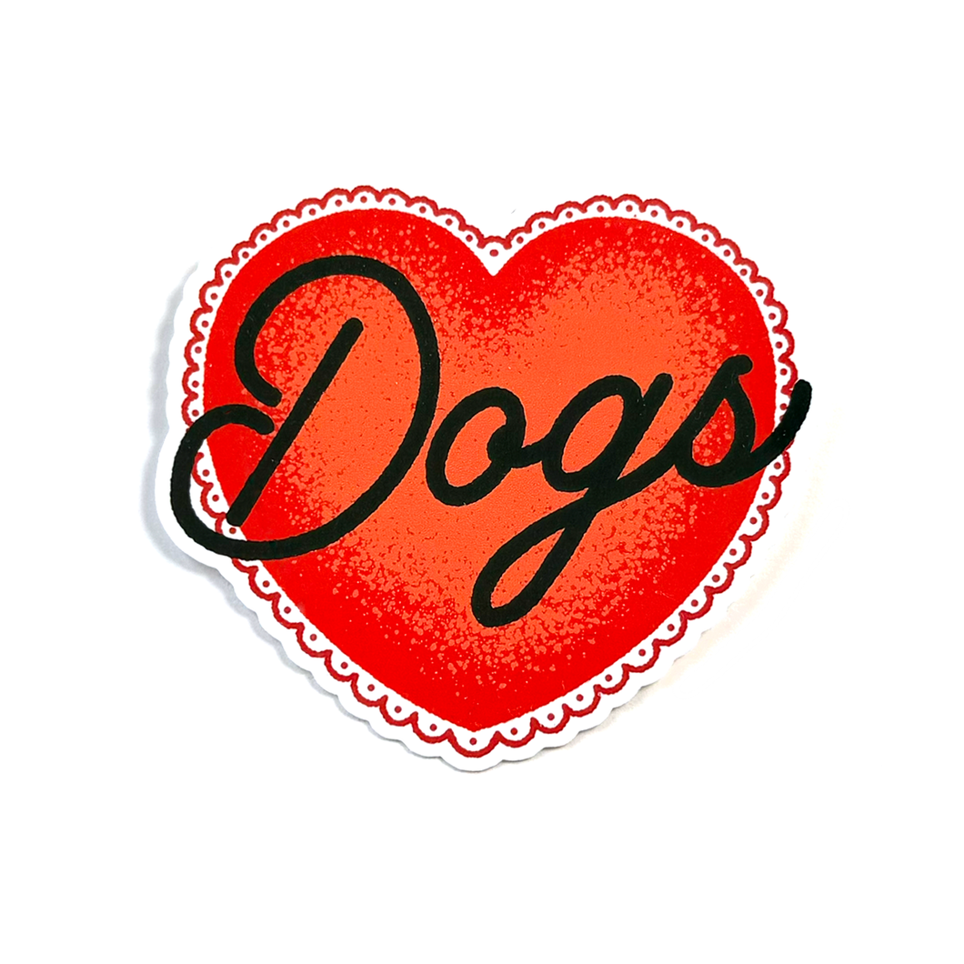 A heart-shaped sticker or decal with a red textured center, a scalloped white border, and the word 'Dogs' written across it in black cursive script, shown on a plain white background.