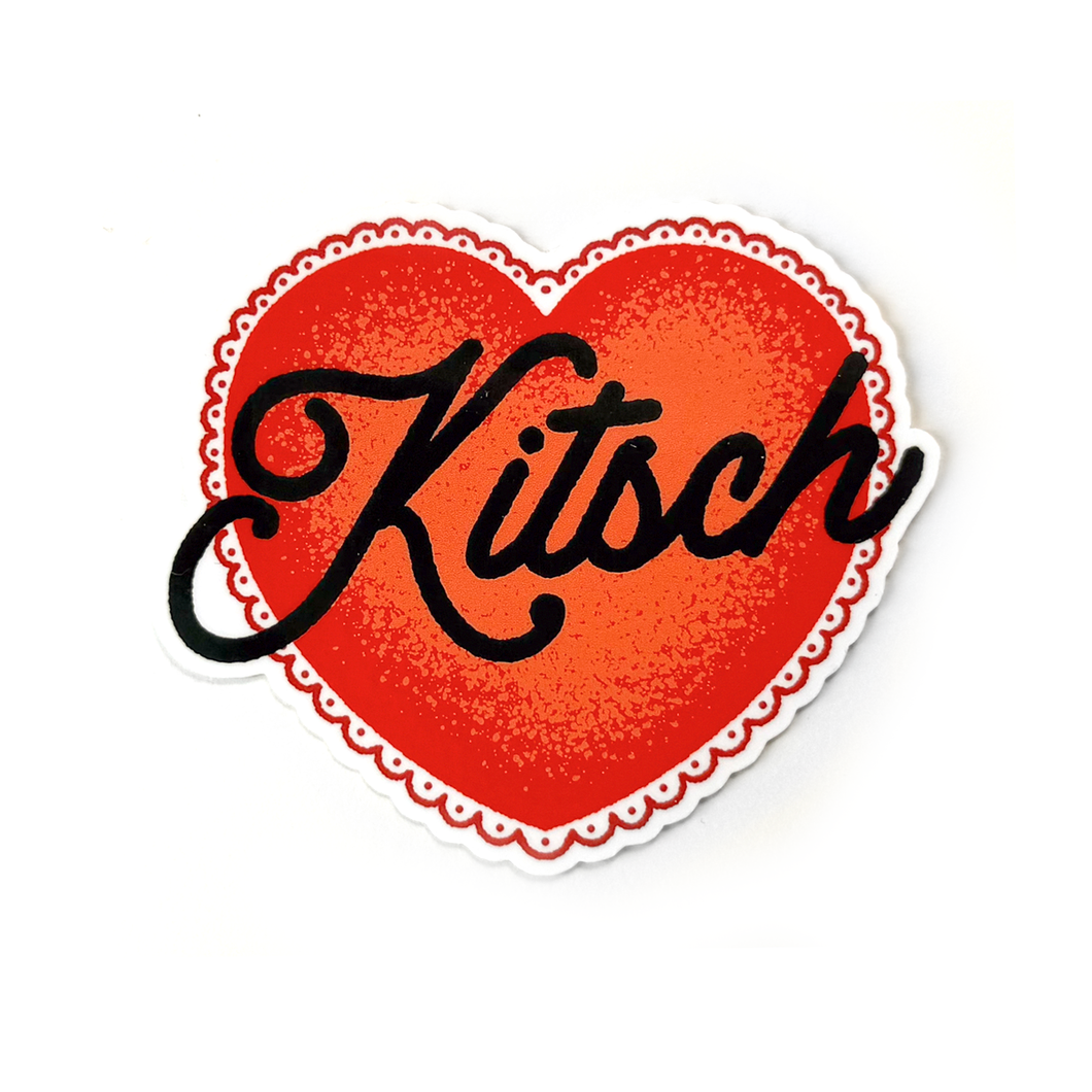 A red heart-shaped sticker with a white scalloped border and the word Kitsch written in black cursive text across the center.