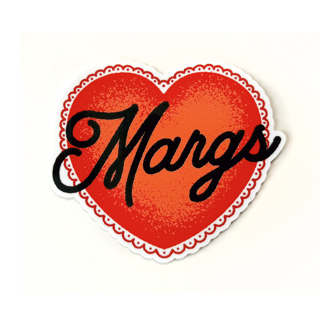A heart-shaped sticker or decal with a red-orange center, a scalloped red-and-white border, and the word 'Marge' in black cursive script, shown on a plain white background.