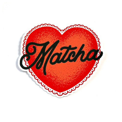 A heart-shaped sticker or decal with a red textured center, a scalloped white border, and the word 'Matcha' written across it in black cursive script, shown on a plain white background.