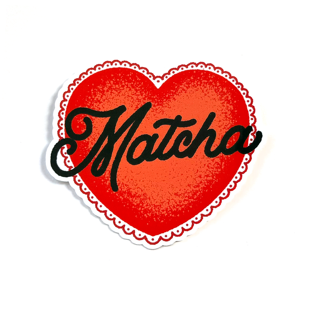 A heart-shaped sticker or decal with a red textured center, a scalloped white border, and the word 'Matcha' written across it in black cursive script, shown on a plain white background.