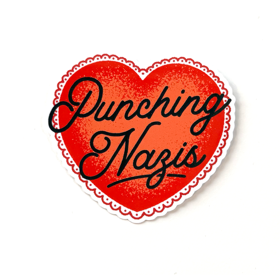 Red heart sticker with black hand-drawn script typography reading “Punching Nazis” in a clean, minimalist political style.