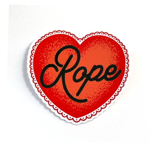 A heart-shaped sticker with a red textured center, black cursive text reading 'Rope', and a white scalloped border on a plain white background.