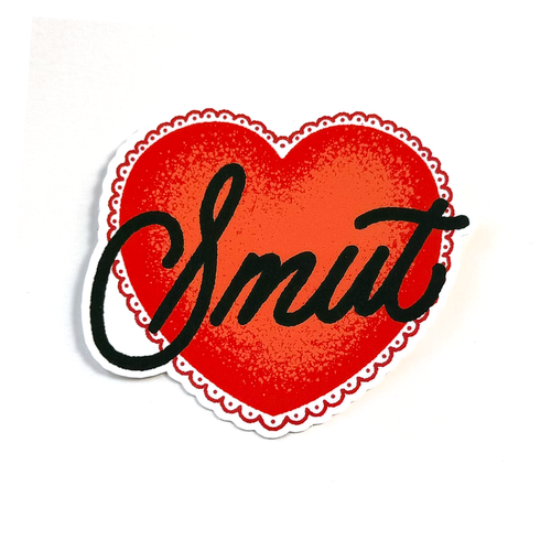 A red heart-shaped sticker with a white scalloped border features the word Smut written in bold black cursive lettering.